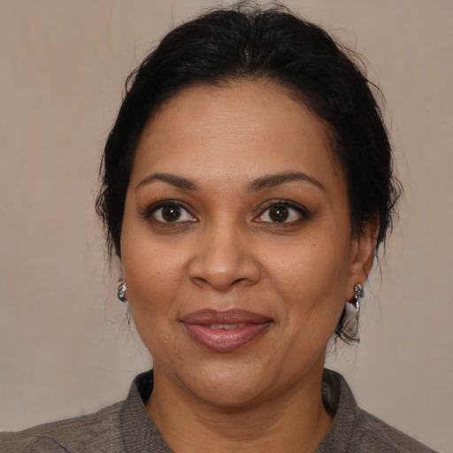 Joyful latino adult female with medium  brown hair and brown eyes