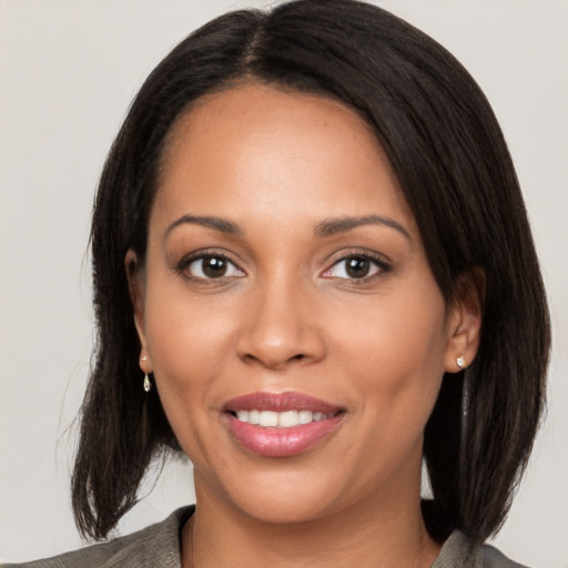 Joyful latino young-adult female with medium  brown hair and brown eyes