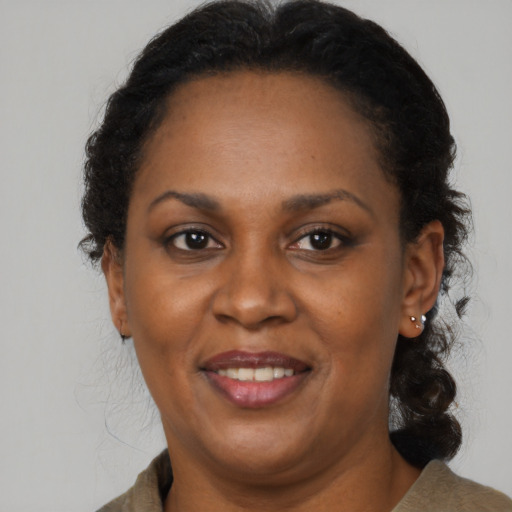 Joyful black adult female with medium  brown hair and brown eyes