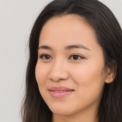 Joyful asian young-adult female with long  brown hair and brown eyes