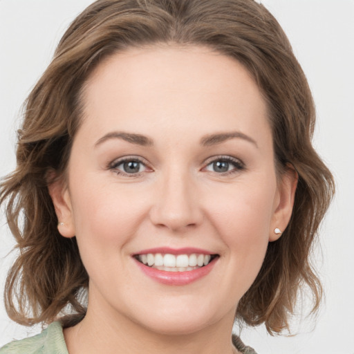 Joyful white young-adult female with medium  brown hair and grey eyes