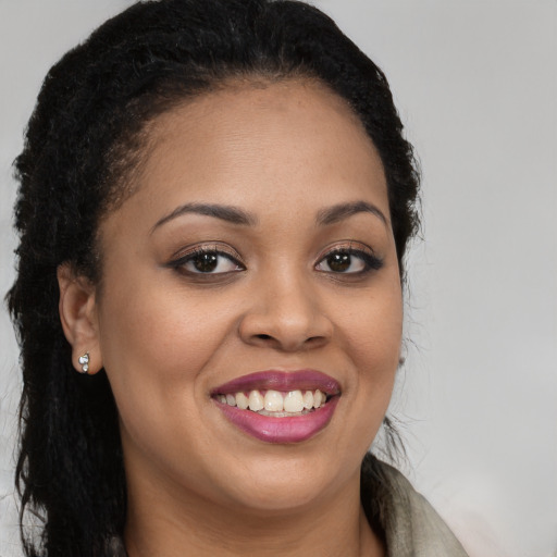 Joyful black young-adult female with long  brown hair and brown eyes