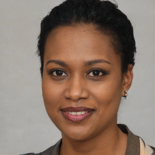 Joyful black young-adult female with short  black hair and brown eyes