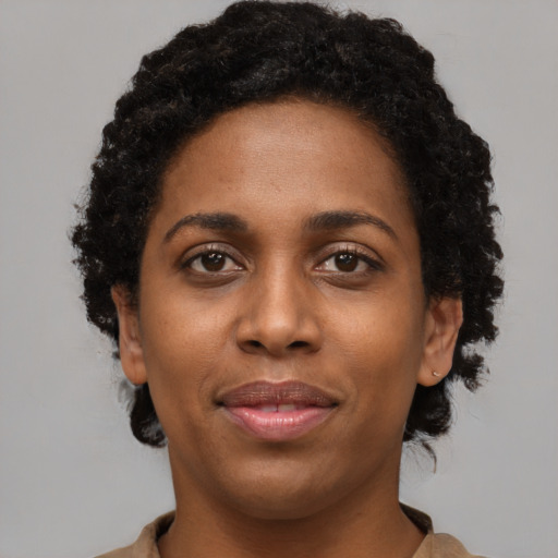 Joyful black young-adult female with short  brown hair and brown eyes