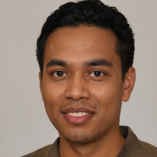 Joyful latino young-adult male with short  black hair and brown eyes