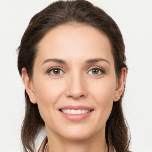 Joyful white young-adult female with long  brown hair and brown eyes