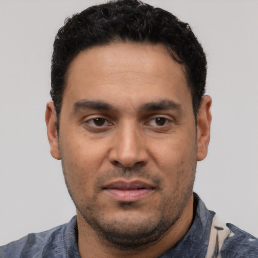 Neutral latino adult male with short  black hair and brown eyes