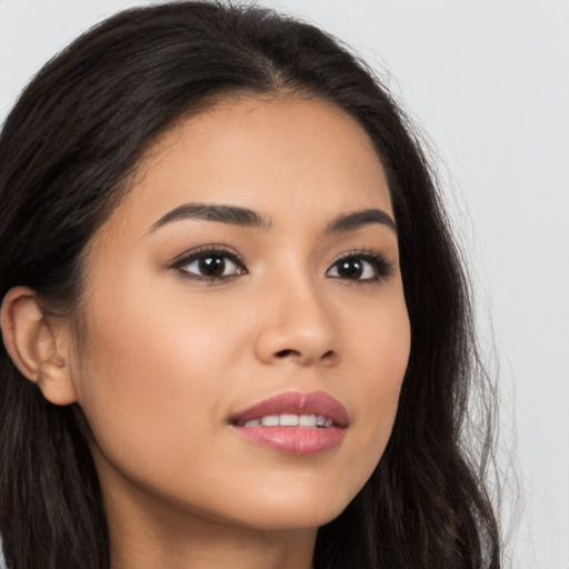 Joyful latino young-adult female with long  brown hair and brown eyes