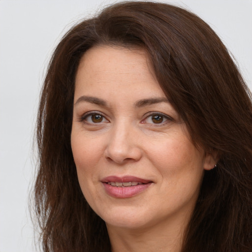 Joyful white adult female with long  brown hair and grey eyes