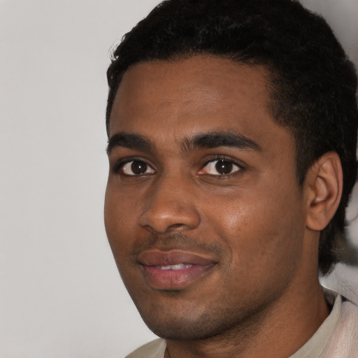 Joyful black young-adult male with short  black hair and brown eyes
