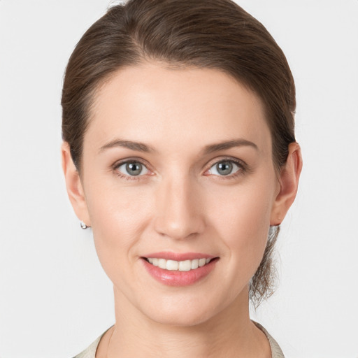 Joyful white young-adult female with medium  brown hair and grey eyes