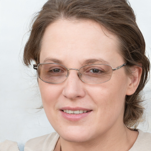 Joyful white adult female with medium  brown hair and blue eyes