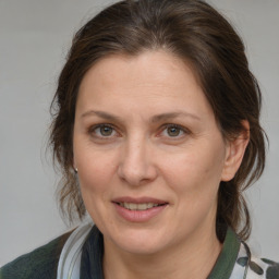 Joyful white adult female with medium  brown hair and grey eyes