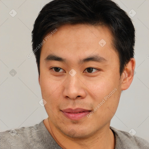 Joyful asian young-adult male with short  brown hair and brown eyes