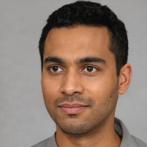 Joyful latino young-adult male with short  black hair and brown eyes