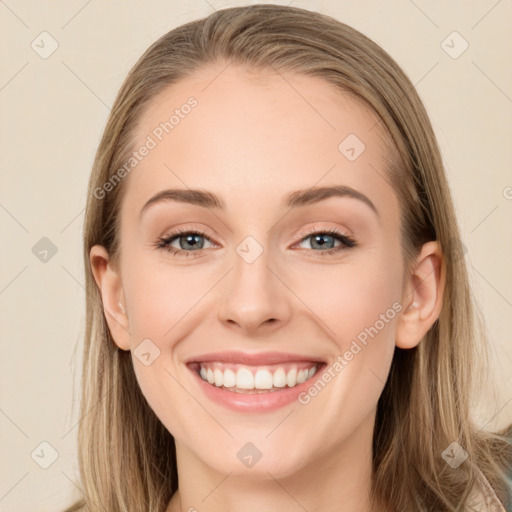 Joyful white young-adult female with long  brown hair and blue eyes