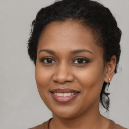 Joyful black young-adult female with long  brown hair and brown eyes