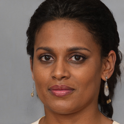 Joyful black young-adult female with medium  brown hair and brown eyes