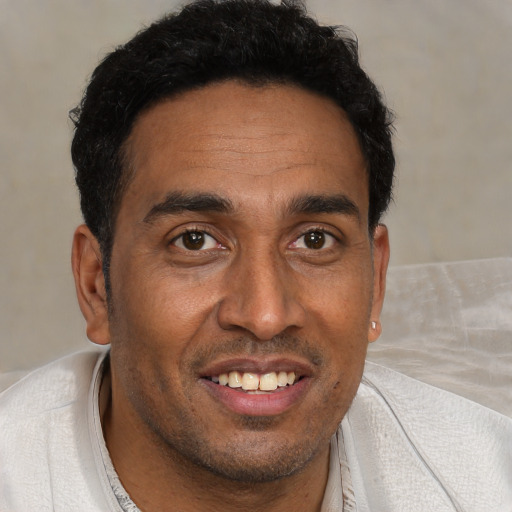 Joyful black young-adult male with short  brown hair and brown eyes