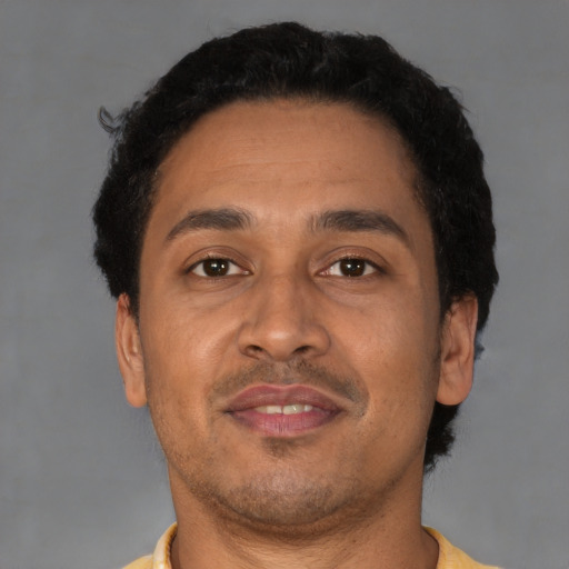 Joyful latino adult male with short  brown hair and brown eyes