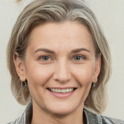 Joyful white adult female with medium  brown hair and green eyes