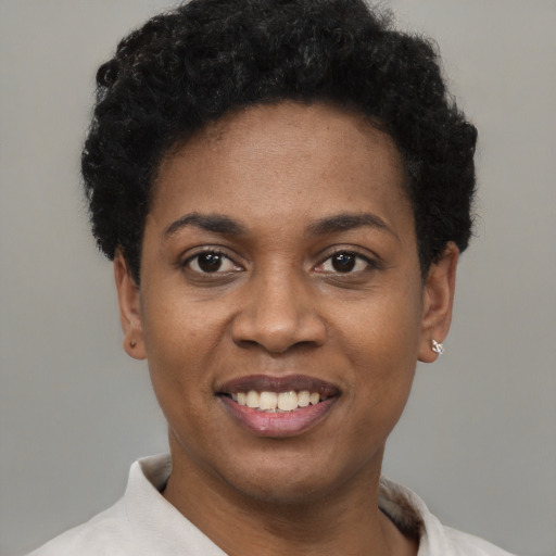 Joyful black young-adult female with short  black hair and brown eyes