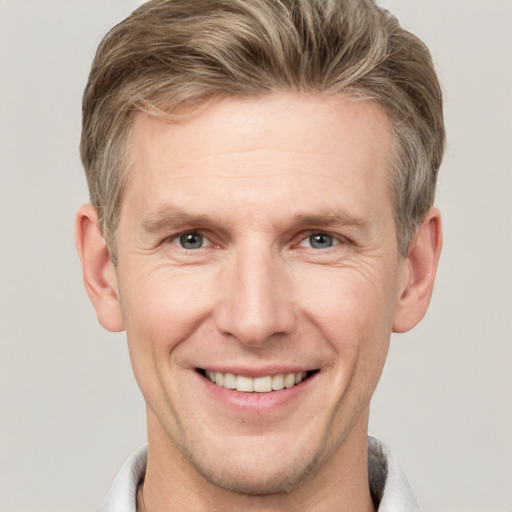 Joyful white adult male with short  brown hair and grey eyes