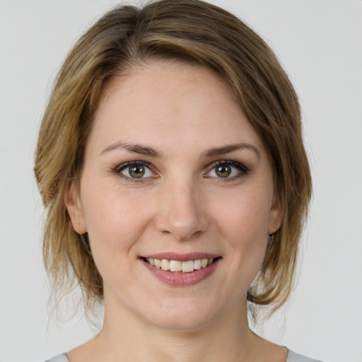 Joyful white young-adult female with medium  brown hair and green eyes