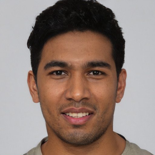 Joyful latino young-adult male with short  black hair and brown eyes