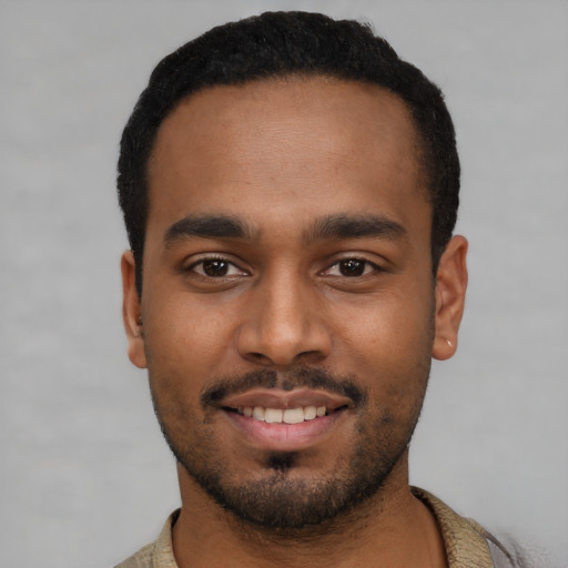 Joyful black young-adult male with short  black hair and brown eyes