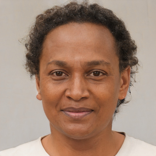 Joyful black adult female with short  brown hair and brown eyes