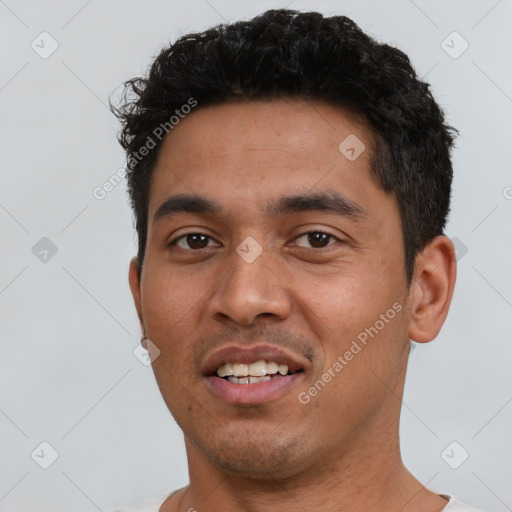 Joyful latino young-adult male with short  black hair and brown eyes