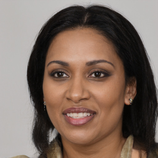 Joyful black adult female with long  black hair and brown eyes