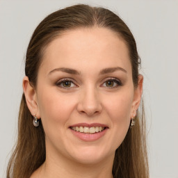 Joyful white young-adult female with long  brown hair and green eyes