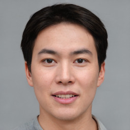 Joyful asian young-adult male with short  brown hair and brown eyes