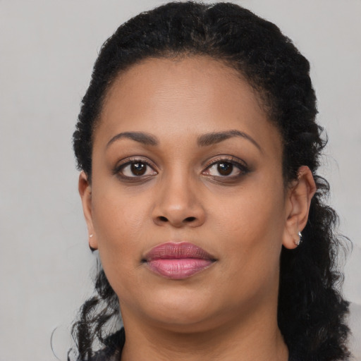 Joyful black young-adult female with long  brown hair and brown eyes