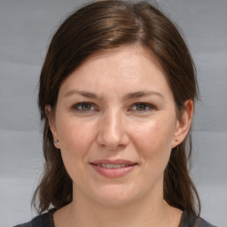 Joyful white young-adult female with medium  brown hair and grey eyes