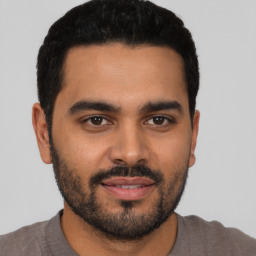 Joyful latino young-adult male with short  black hair and brown eyes