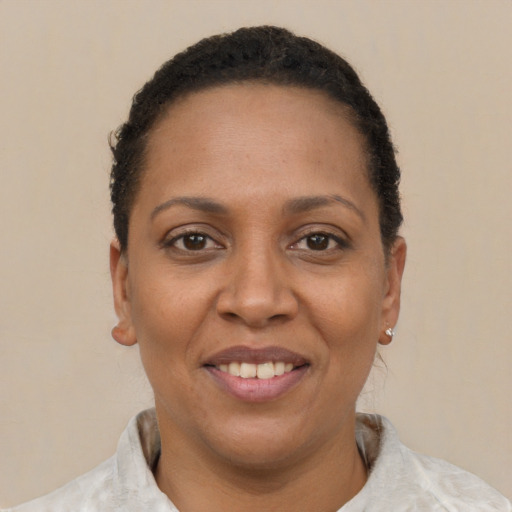 Joyful black adult female with short  brown hair and brown eyes