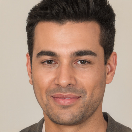 Joyful white young-adult male with short  black hair and brown eyes