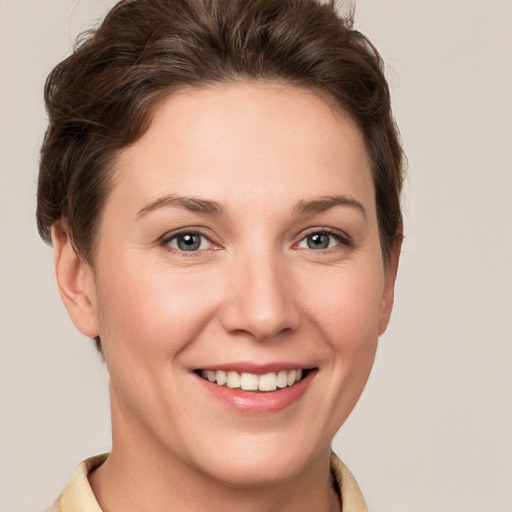 Joyful white young-adult female with short  brown hair and grey eyes