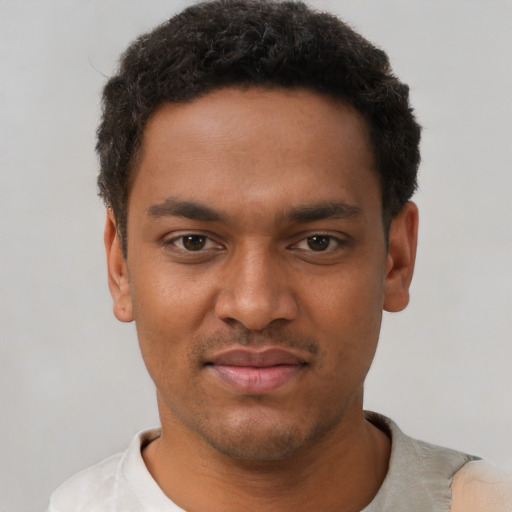 Joyful black young-adult male with short  black hair and brown eyes