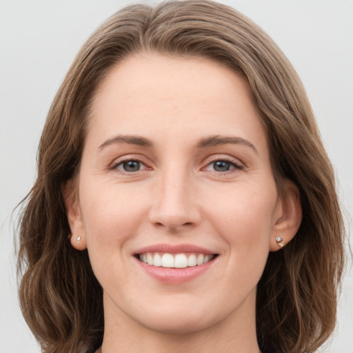 Joyful white young-adult female with long  brown hair and grey eyes