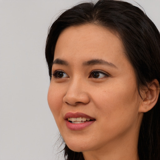 Joyful asian young-adult female with long  brown hair and brown eyes