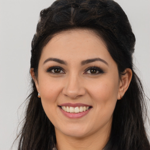 Joyful latino young-adult female with long  brown hair and brown eyes