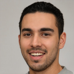 Joyful white young-adult male with short  black hair and brown eyes