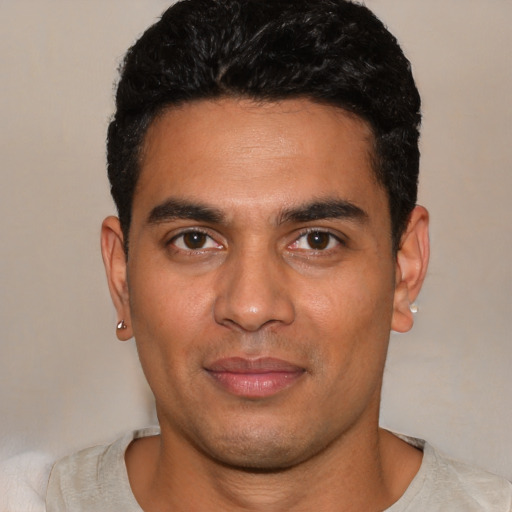 Joyful latino young-adult male with short  black hair and brown eyes