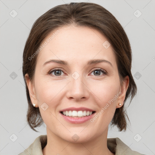 Joyful white young-adult female with medium  brown hair and grey eyes