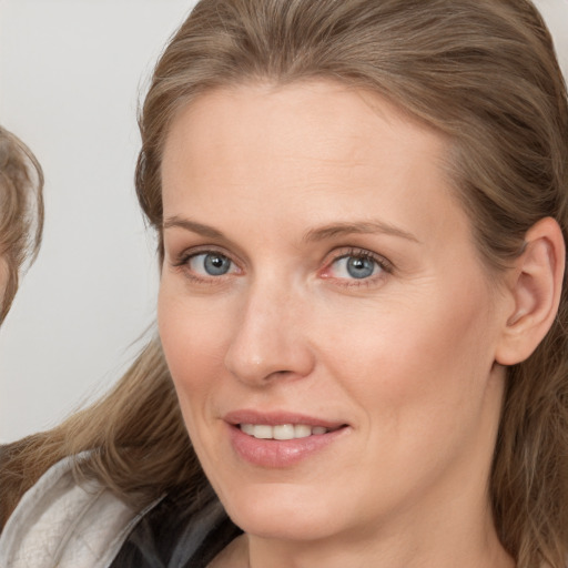 Joyful white young-adult female with medium  brown hair and blue eyes