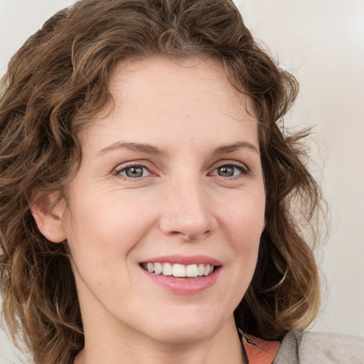 Joyful white young-adult female with medium  brown hair and green eyes